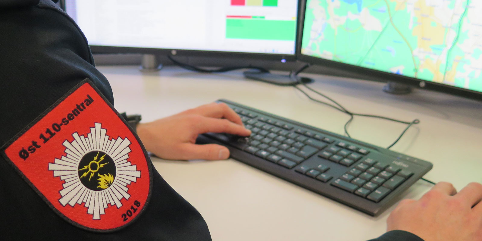 Nærbilde av en som sitter å jobber på 110-sentralen