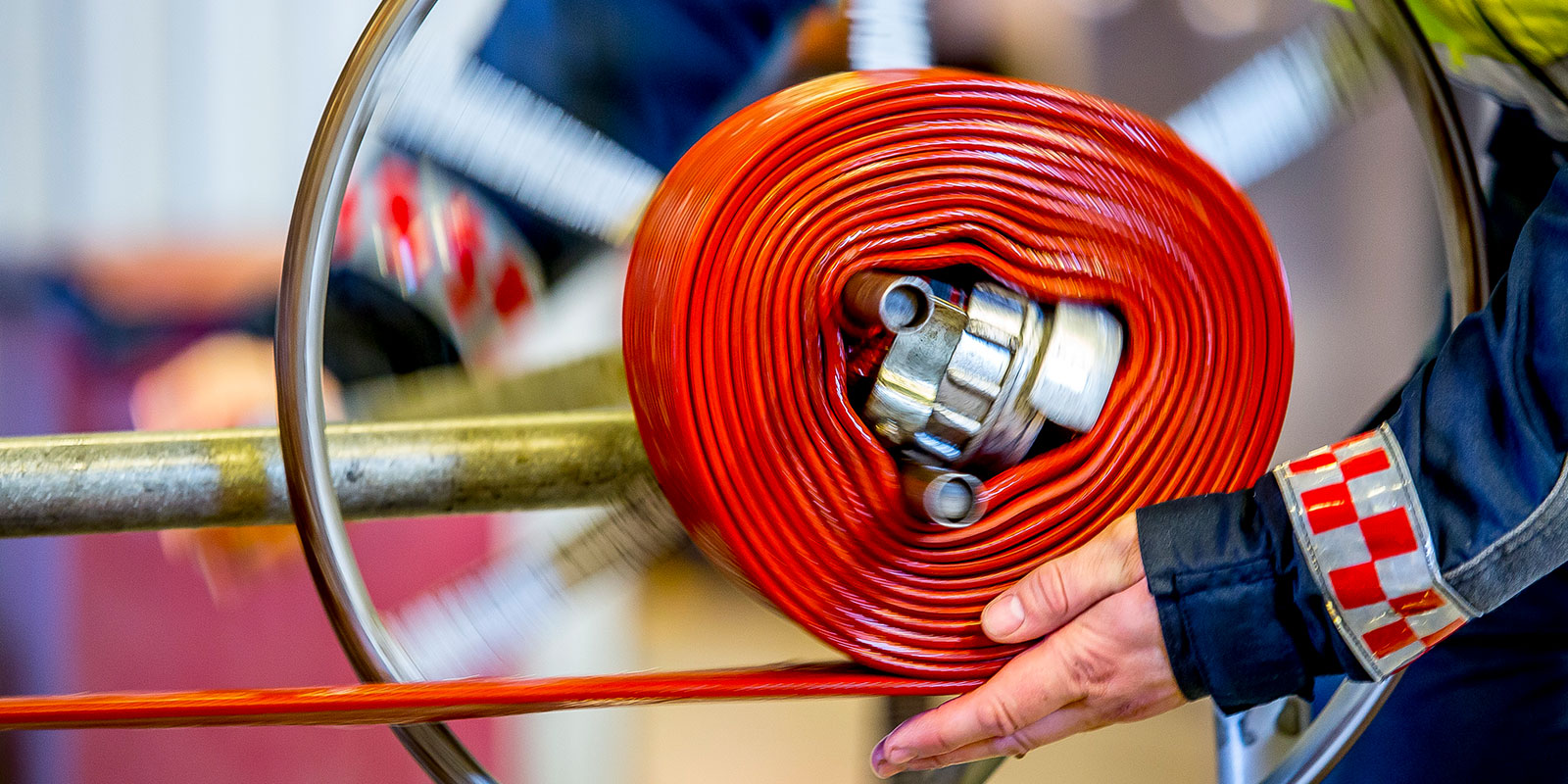 Nær bilde av en brannmann utfører slangerulling